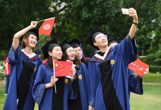 Students celebrating graduation with flags